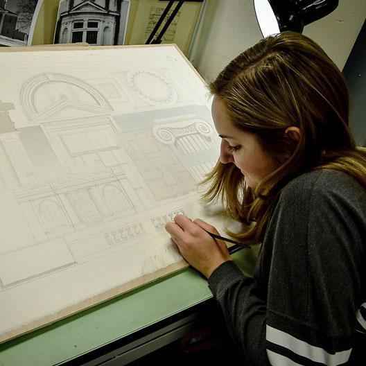 A student at a drafting table in Architecture class
